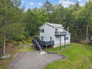 A two-story house with a balcony, surrounded by trees. - Lakeview Retreat | Theater, Games & 140 Acres (Monticello)