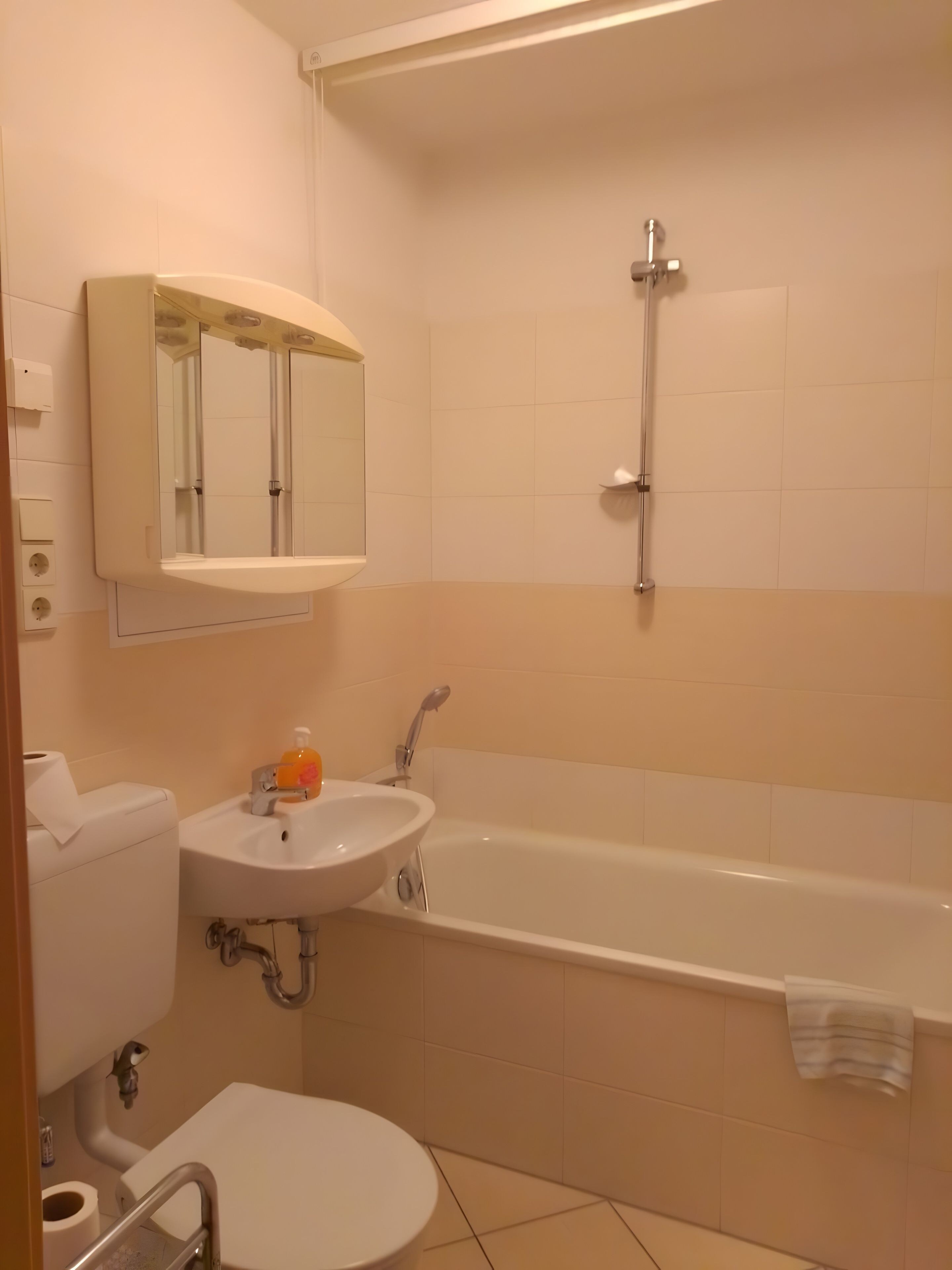 A bathroom with a toilet, sink, and bathtub.