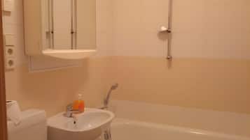 A bathroom with a toilet, sink, and bathtub.