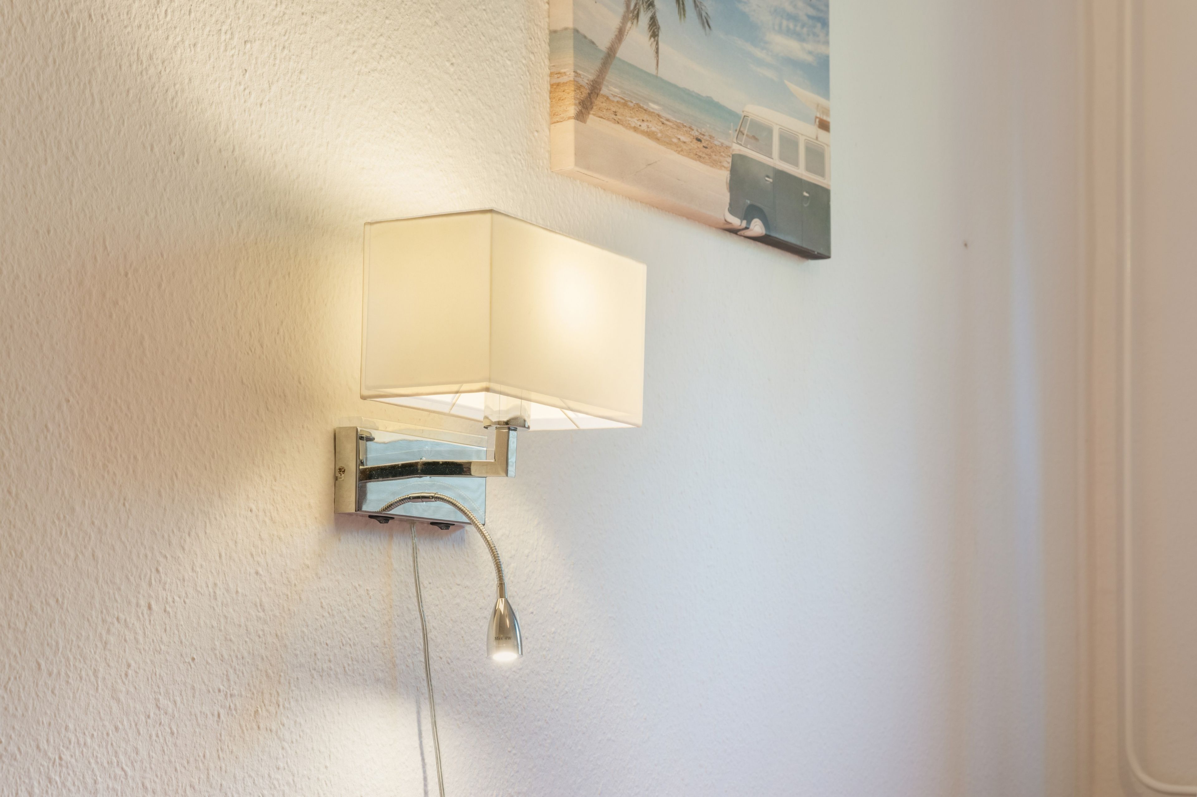 Eine an der Wand befestigte Leuchte mit sichtbarem Stromkabel.