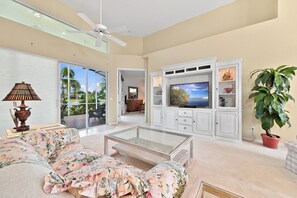 A living room with a sofa, TV, ceiling fan, and a potted plant. - Lakeview home with Golf - 5 Minutes to Gulf Beaches (Bonita Springs)
