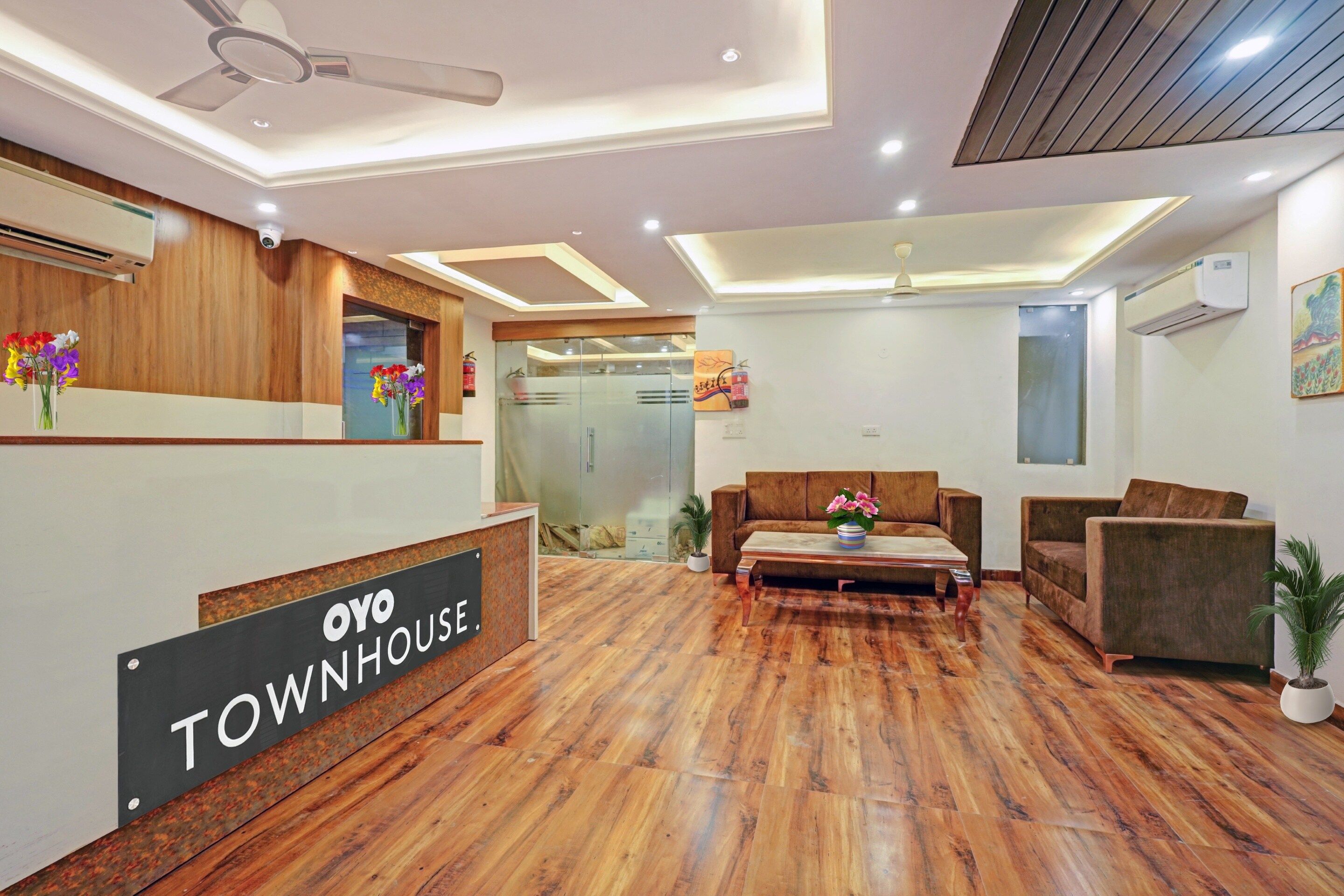 A reception area with a wooden reception desk, a sofa, and a coffee table.