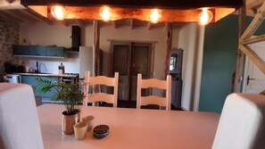 A dining area with a table, chairs, and a potted plant. - Holiday Home 'Le Pinatou Haut' with Garden (Bellevue-la-Montagne)