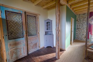 A rustic hallway with wooden doors, a stone wall, and a wooden cabinet. - Holiday Home 'Le Pinatou Haut' with Garden (Bellevue-la-Montagne)