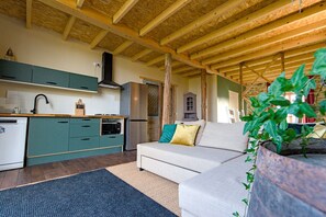 A cozy kitchen with wooden beams, a built-in stove, and a refrigerator. - Holiday Home 'Le Pinatou Haut' with Garden (Bellevue-la-Montagne)
