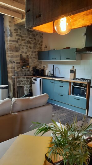 Un'accogliente zona giorno con divano, tavolo da pranzo e una pianta in vaso.
