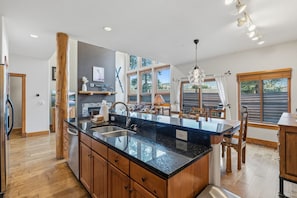 A modern kitchen with a large island, wooden cabinets, and a view of the outdoors. - Spacious and Inviting Frisco Retreat (Frisco)