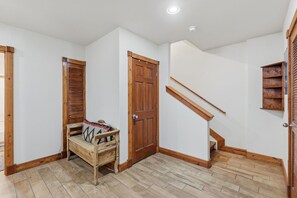 A room with a wooden bench, a wooden door, and a wooden staircase. - Spacious and Inviting Frisco Retreat (Frisco)