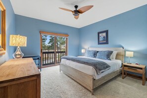 A bedroom with a bed, bedside tables, a ceiling fan, and a view through a sliding door. - Spacious and Inviting Frisco Retreat (Frisco)
