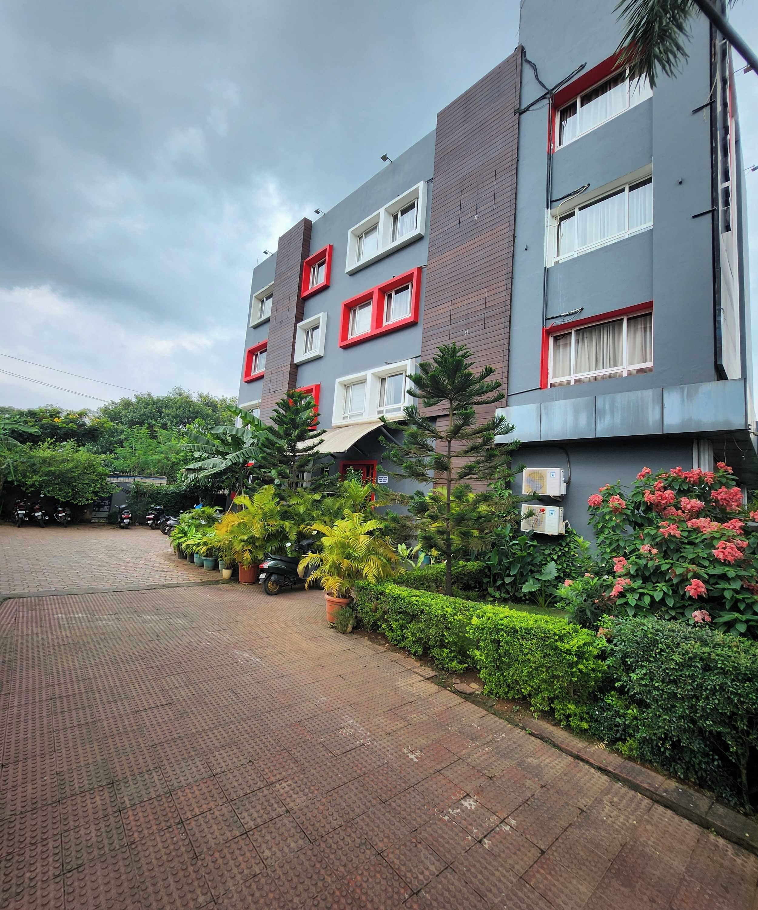 Un edificio de varios pisos con fachada de ladrillo y marcos de ventanas rojos.