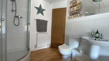 A bathroom with a shower, toilet, sink, and a star decoration on the wall.