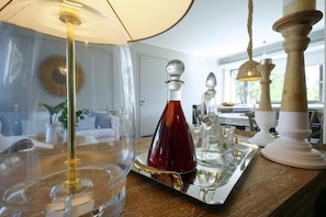 En matplats med ett bord dukat för två personer, en lampa och en dekorativ glasvas.