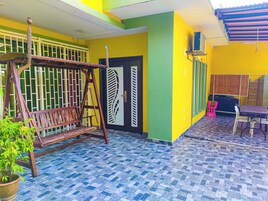 A room with a swing set, a door with a decorative panel, and a tiled floor.