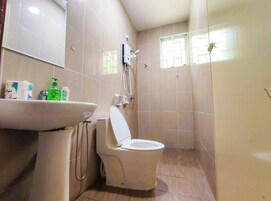 A bathroom with a toilet, sink, and shower.