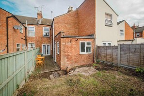 A residential property with a brick house, a wooden deck, and a fenced yard. - Comfortable 3 Bedroom Townhouse Sleeps 6 (Northampton)