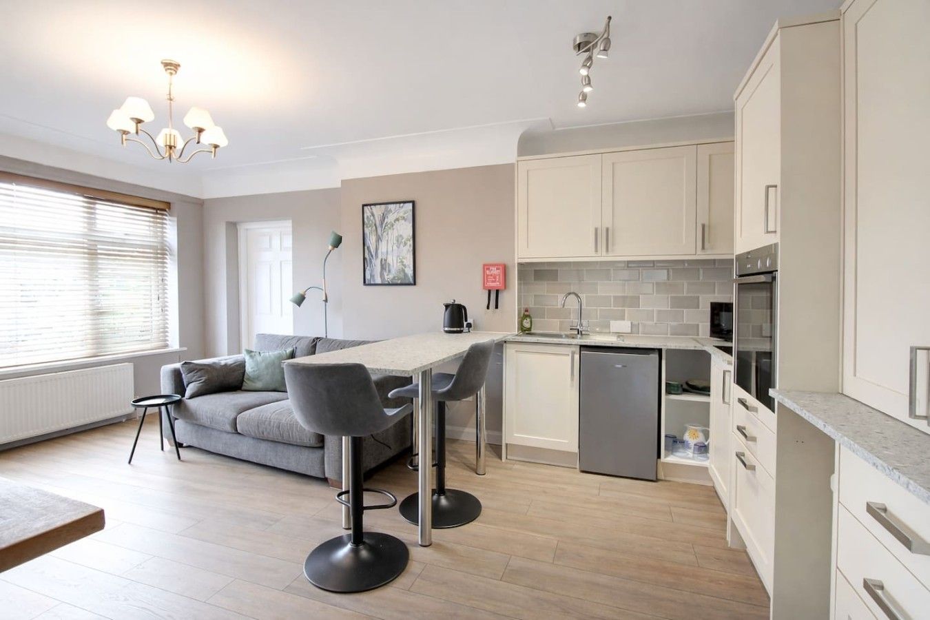 A modern kitchen with a dining area, a sofa, and a coffee table.