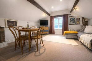 A cozy living room with a dining area, a sofa, a TV, and a fireplace. - Apartment on Watergate Street: Cheshire Escapes (Cheshire West and Chester)