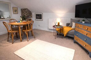A cozy room with a dining table, chairs, a sofa, a TV, and a dresser. - Apartment on Watergate Street: Cheshire Escapes (Cheshire West and Chester)