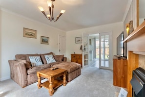 A living room with a sofa, coffee table, and a fireplace. - Barbridge Canal Holiday (Cheshire East)