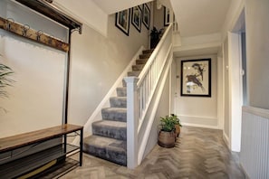 A staircase with a wooden handrail and a bench at the bottom. - The Botanical Holiday by Cheshire Escapes (Cheshire West and Chester)