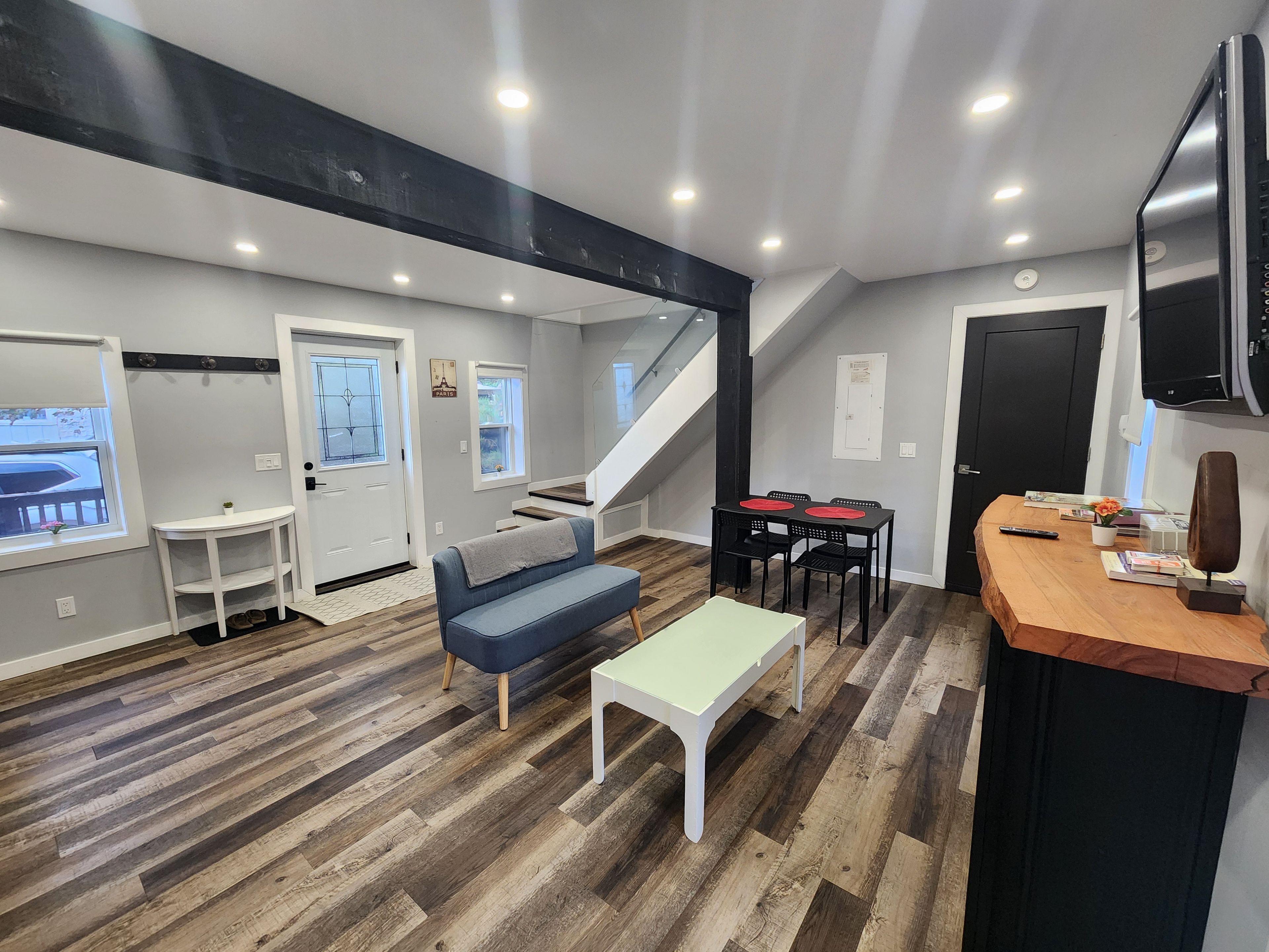Un intérieur moderne avec un escalier, un coin salon et une table à manger.