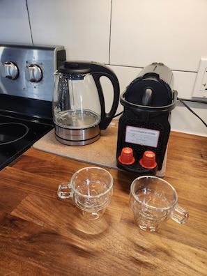 A kitchen counter with a coffee maker, a kettle, and two empty glasses. - Lovely renovated one bedroom getaway (Meaford)