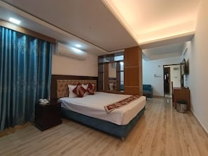 A hotel room with a large bed, a bedside table, a mirror, and a wardrobe. - Hotel D Palace (Dhaka)
