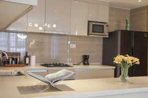 A modern kitchen with a built-in microwave, a stainless steel refrigerator, and a coffee machine. - Elegant 2-Bedroom Luxury Retreat at GTC Residency (Nairobi)