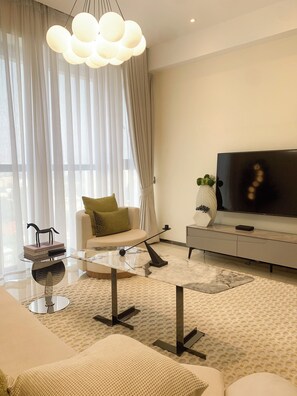 Una sala de estar moderna con un sofá, una mesa de centro, un televisor y una planta decorativa.