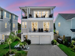 A two-story residential building with a garage, a balcony, and a well-maintained garden. - Golden Palms at St. Augustine | Luxury, Pool + Nearby Beach Access (St. Augustine)