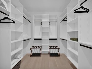 A walk-in closet with multiple shelves and two wooden benches. - Golden Palms at St. Augustine | Luxury, Pool + Nearby Beach Access (St. Augustine)