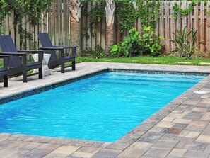 A rectangular swimming pool with a tiled edge, surrounded by a wooden deck and a wooden fence. - Golden Palms at St. Augustine | Luxury, Pool + Nearby Beach Access (St. Augustine)