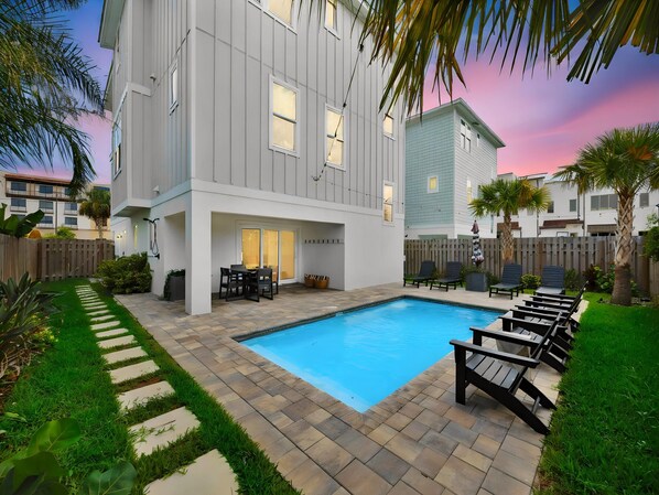 A residential building with a swimming pool, outdoor seating, and a well-maintained garden. - Golden Palms at St. Augustine | Luxury, Pool + Nearby Beach Access (St. Augustine)