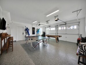 A spacious room with a ping pong table, a dartboard, and a billiards table. - Golden Palms at St. Augustine | Luxury, Pool + Nearby Beach Access (St. Augustine)