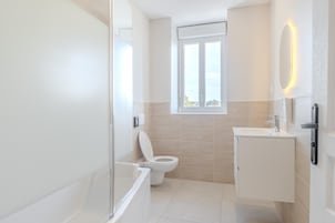 A modern bathroom with a toilet, sink, and shower.