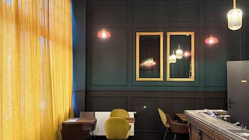 Een restaurantinterieur met een bar, gele stoelen en hanglampen.