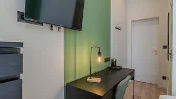 A modern room with a desk, chair, and a mounted TV.