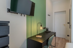 A modern room with a desk, chair, and a mounted TV.