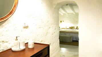 Un baño con tocador de madera, un espejo grande y un lavabo blanco.