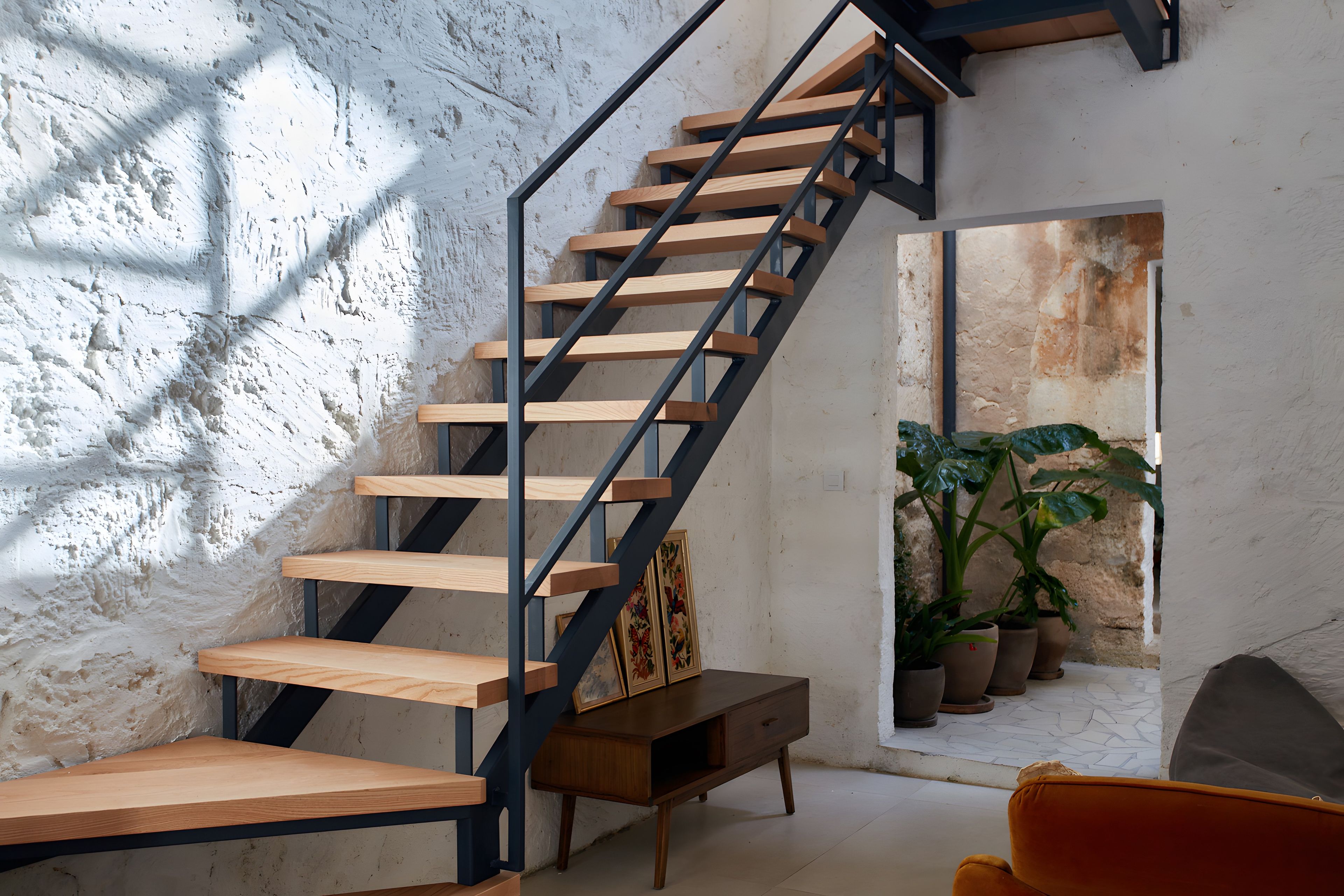 Un escalier avec des marches en bois et une rampe en métal.