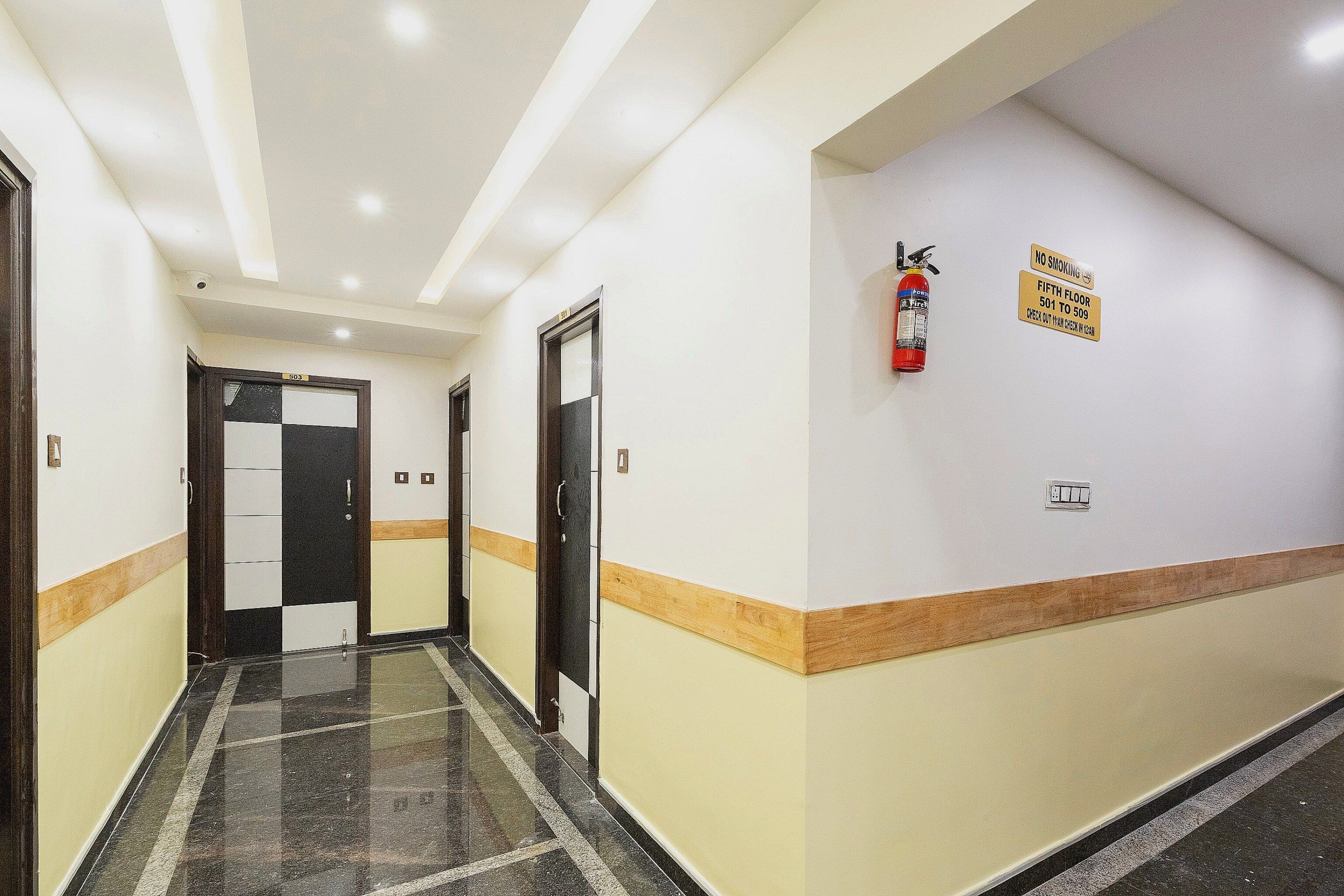 A hotel corridor with doors numbered 503 and 501, a fire extinguisher, and a no smoking sign on the wall.