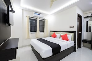 Una habitación de hotel moderna con cama, televisor de pantalla plana, aire acondicionado y ventilador de techo.