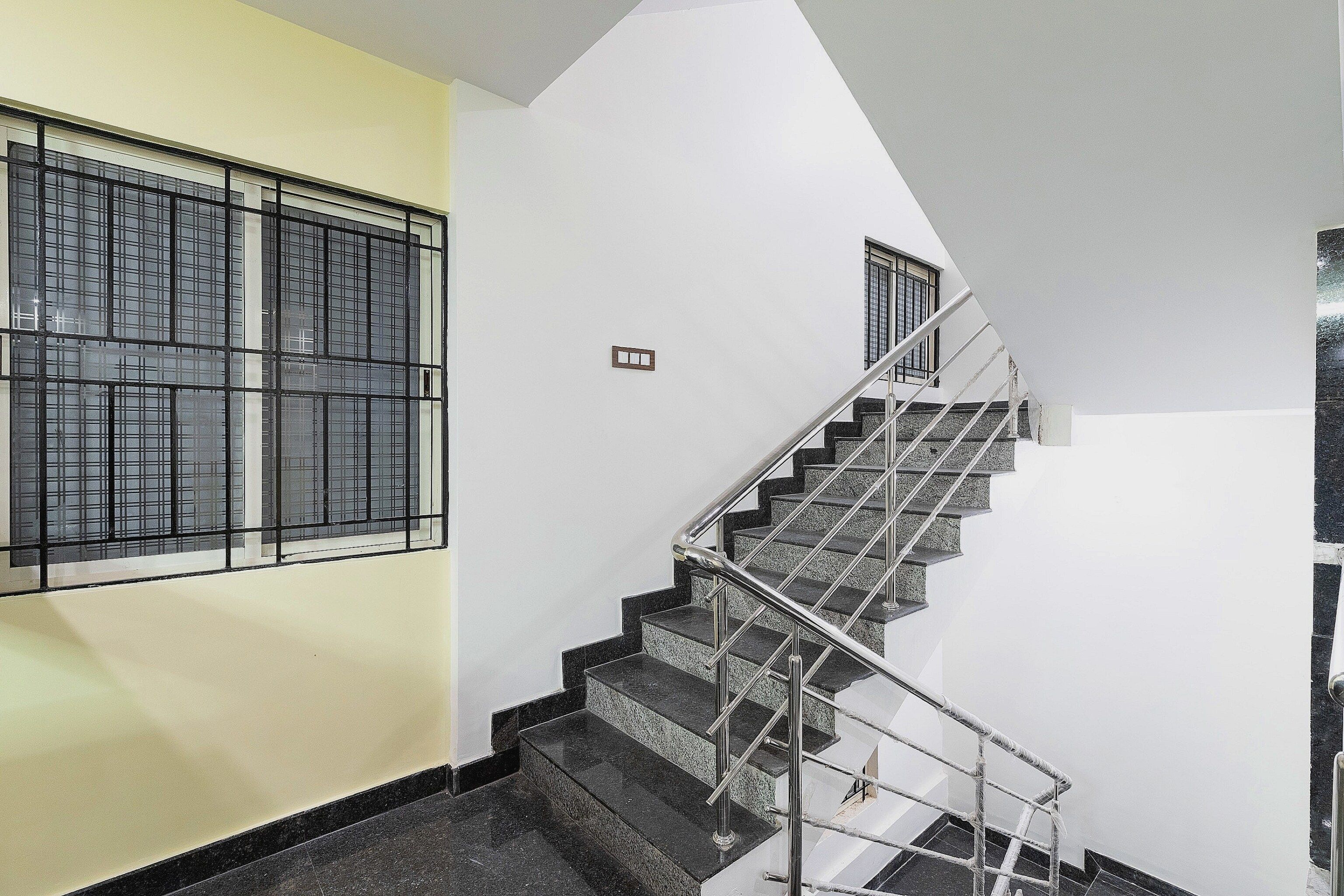 Una escalera con barandas de metal que lleva a un piso superior.