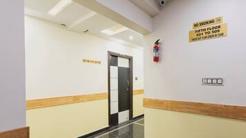 A hotel corridor with a check-in desk, a fire extinguisher, and directional signs for rooms 501 to 509.