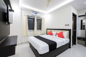 Un dormitorio moderno con una cama, un televisor de pantalla plana, un equipo de aire acondicionado y un ventilador de techo.
