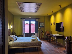 A room with a bed, a desk, a television, and a window with curtains. - Vrbo Property (toledo)