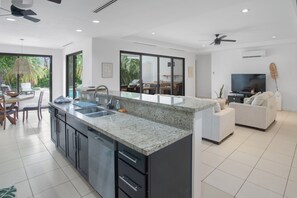 Eine moderne Küche mit Granit Arbeitsplatte, integriertem Geschirrspüler und einem Essbereich mit Tisch und Stühlen.