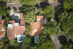 An aerial view of a residential area with multiple houses, a swimming pool, and surrounding greenery. - New Listing • Casa Pacifica • 4BR Villa • Private Pool • Pacifico (Playas del Coco)