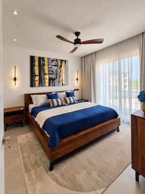Une chambre moderne avec un lit en bois, un ventilateur de plafond et une grande fenêtre avec des rideaux.