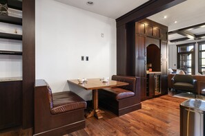 A modern dining area with a wooden table and leather booth seating. - Deer Valley 2 Bedroom Ski-In/Ski-Out Condo With Views 2 Condo (Park City)